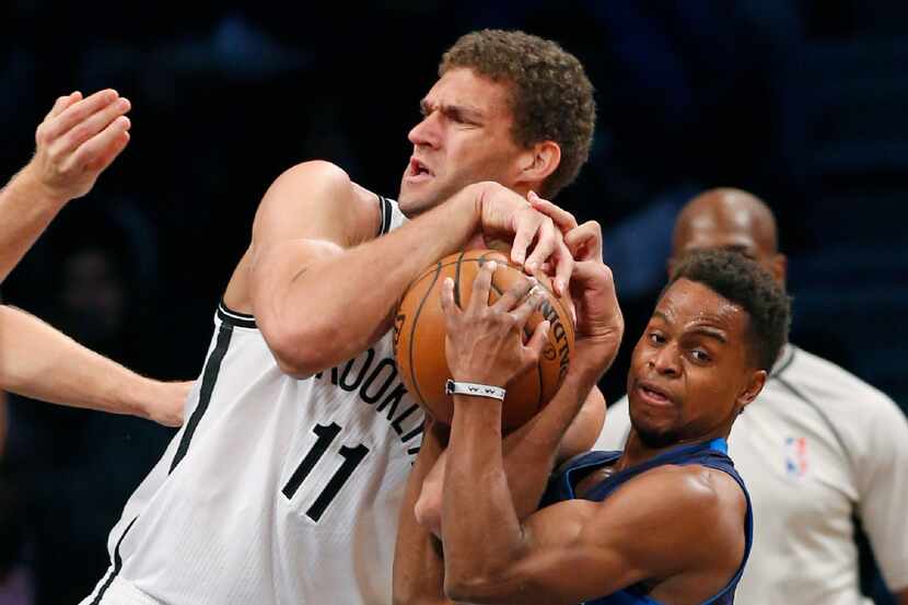 Brooklyn Nets center Brook Lopez, left, and Dallas Mavericks guard Yogi Ferrell battle for...