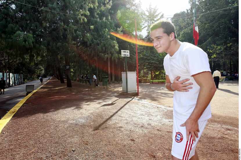 Un hombre en ropa deportiva se toca el pecho.