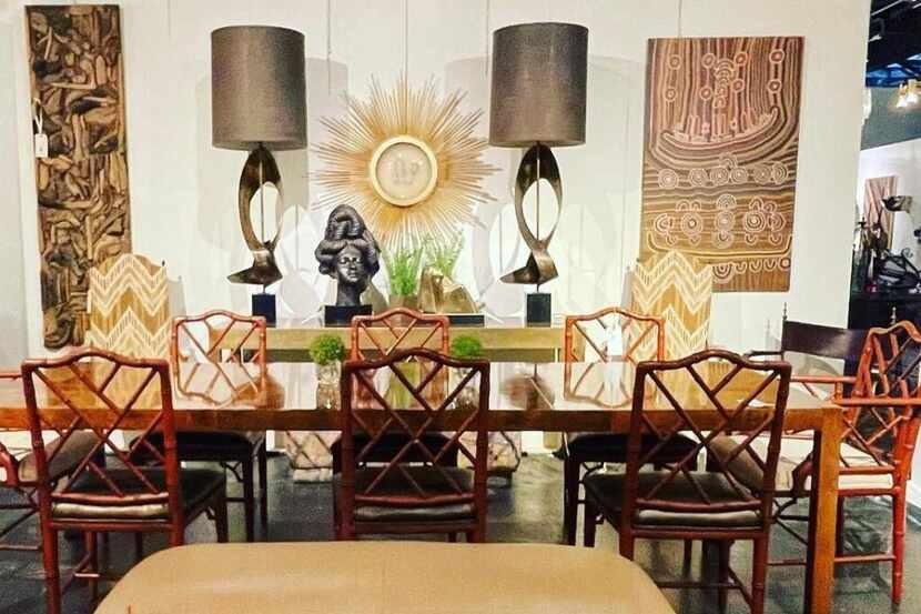 A dining room table with chairs, and a pair of lamps in the background.