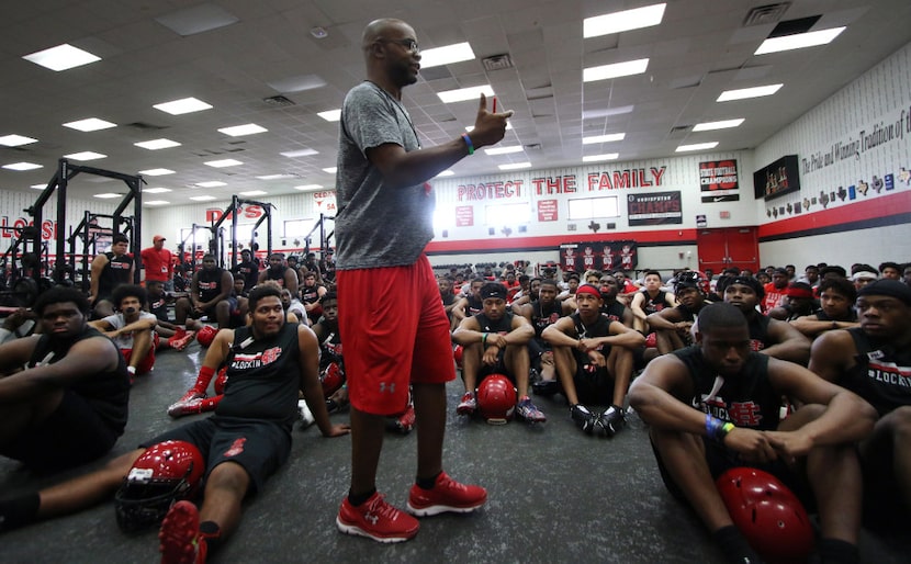 Carlos Lynn, Cedar Hill's new head football coach, speaks with his players as he emphasizes...