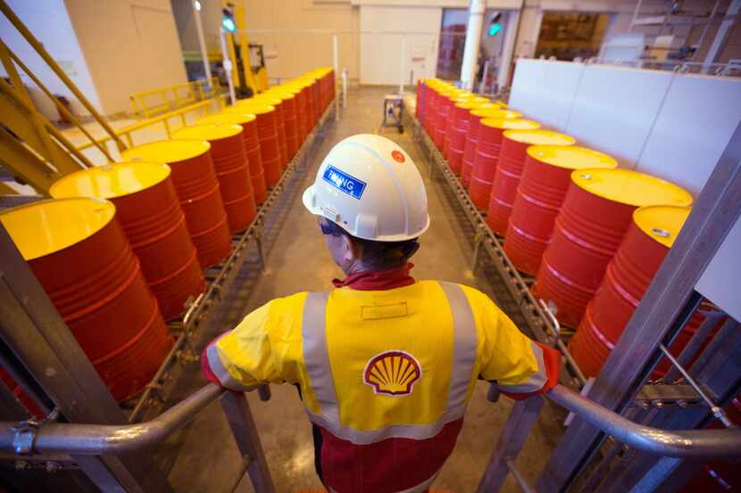 Oil drums containing lubricant oil sit on a conveyor belt as they are prepared for shipping...