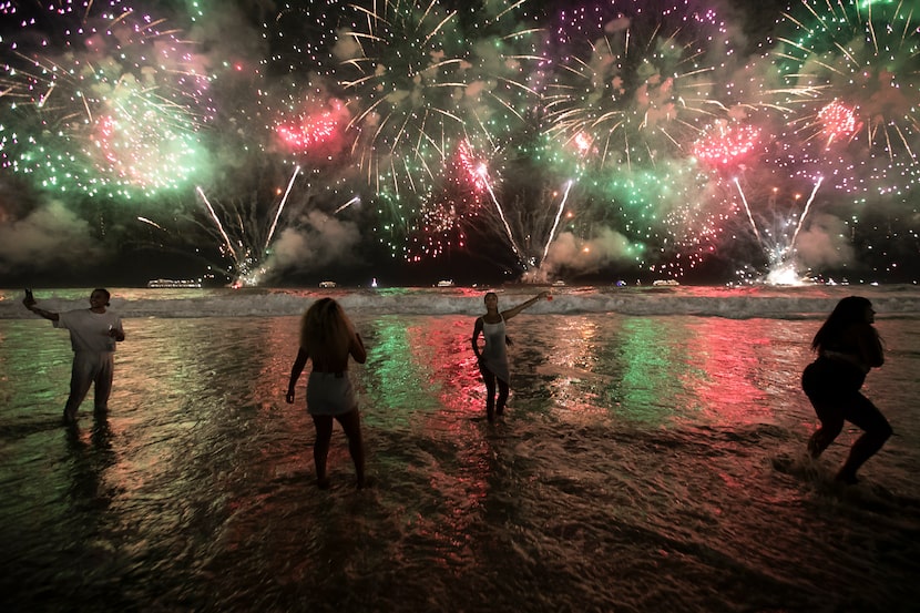 FILE - People celebrate the start of the New Year as fireworks illuminate Copacabana Beach...