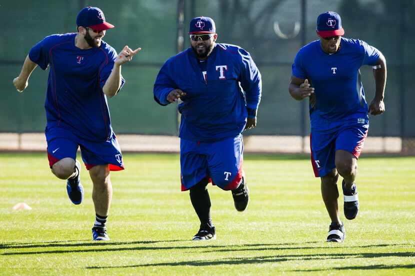 Texas Rangers infielders Mitch Moreland, Prince Fielder and Adrian Beltre run during a...