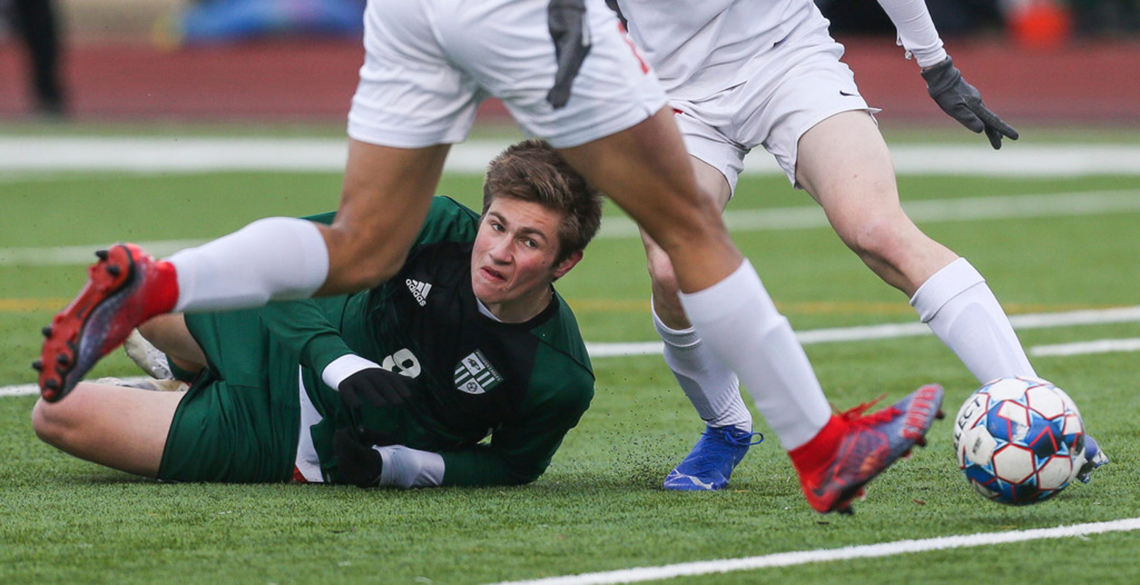 Prosper's Jack Simonini (9) falls to the ground while battling for the ball during Prosper's...