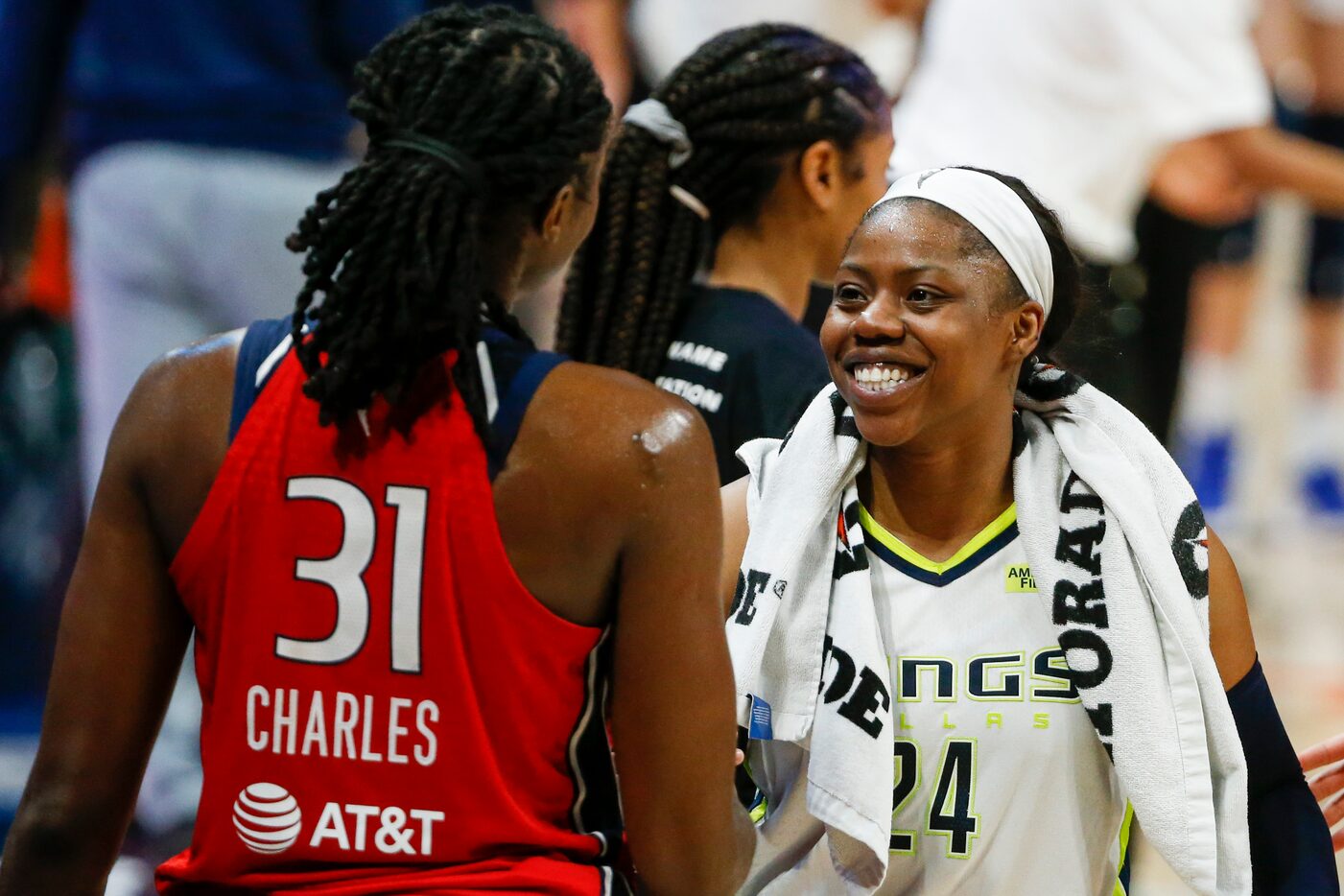 Dallas Wings guard Arike Ogunbowale (24) greets Washington Mystics center Tina Charles (31)...