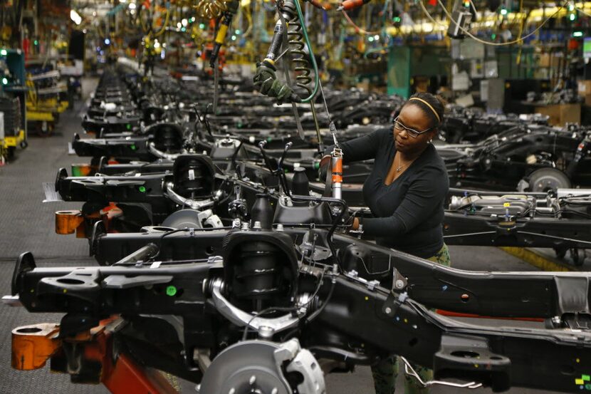 An employee attaches brake components on a chassis at the GM plant in Arlington in 2015.