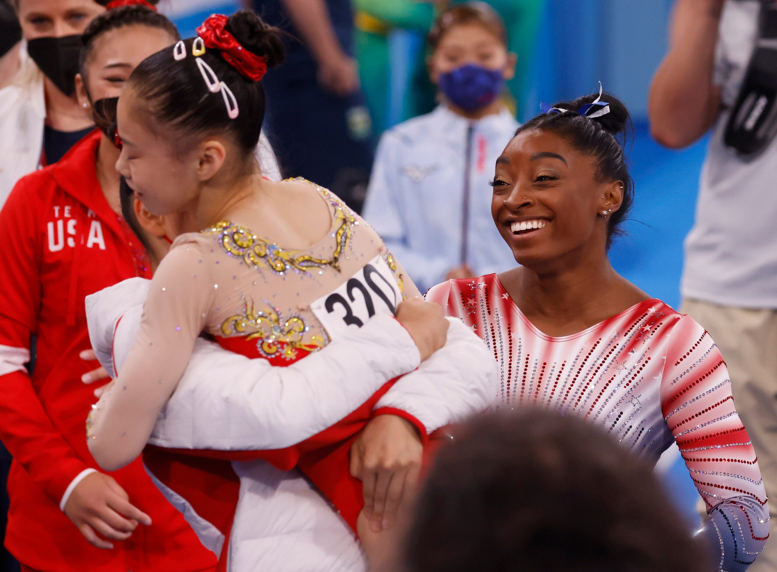 USA’s Simone Biles looks on as China’s Tang Xijing hugs teammate Guan Chenchen after she...