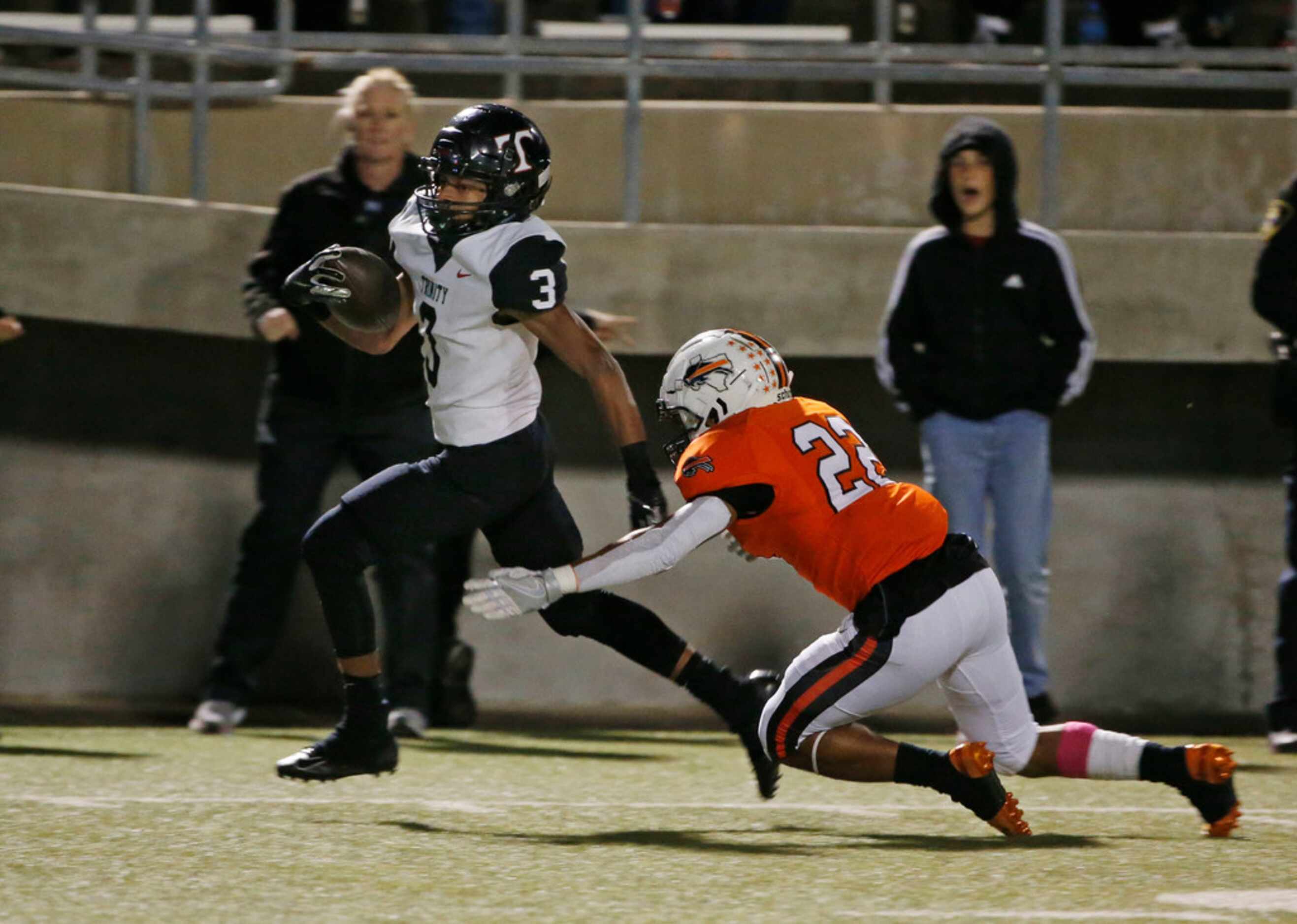 Trinity's Zechariah Moore (3) is tackled by Haltom's Johnny Smith-Rider (22) during the...