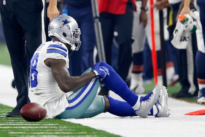Dallas Cowboys wide receiver Dez Bryant (88) grabs his leg after injuring his right knee on...