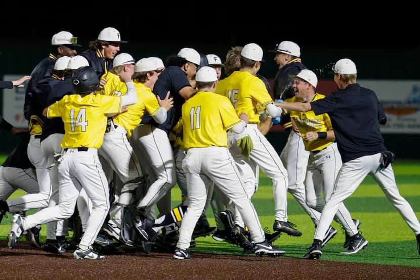 The Forney team celebrates after a walk-off single in the eighth inning of a high school...