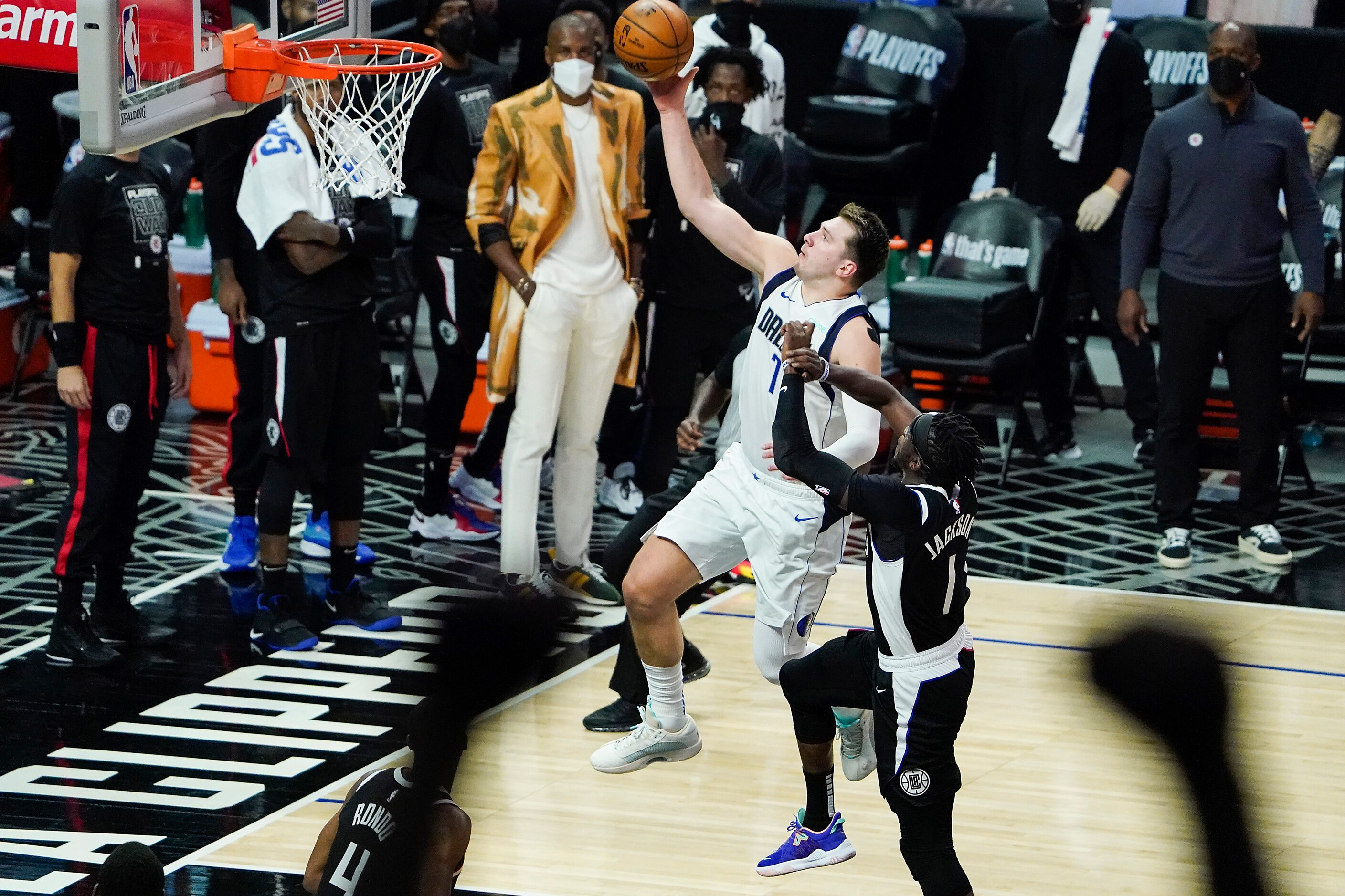 Dallas Mavericks guard Luka Doncic (77) drives for a layup past LA Clippers guard Reggie...