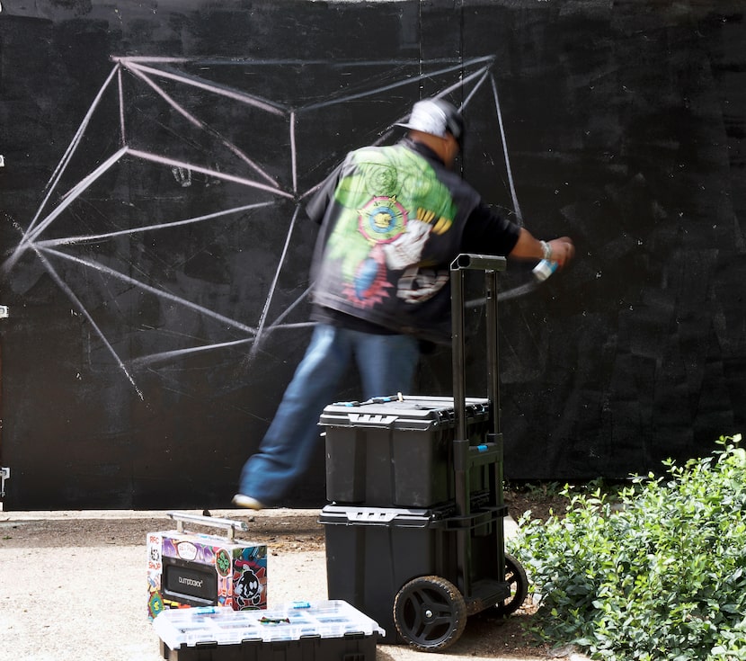 Joselito Vargas Cardenas draws the outline for a mural in Trinity Groves' Art Park and beer...