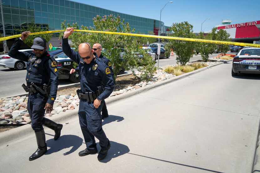 Dallas police chief Eddie Garcia (center) exits under police tape from the scene of a...