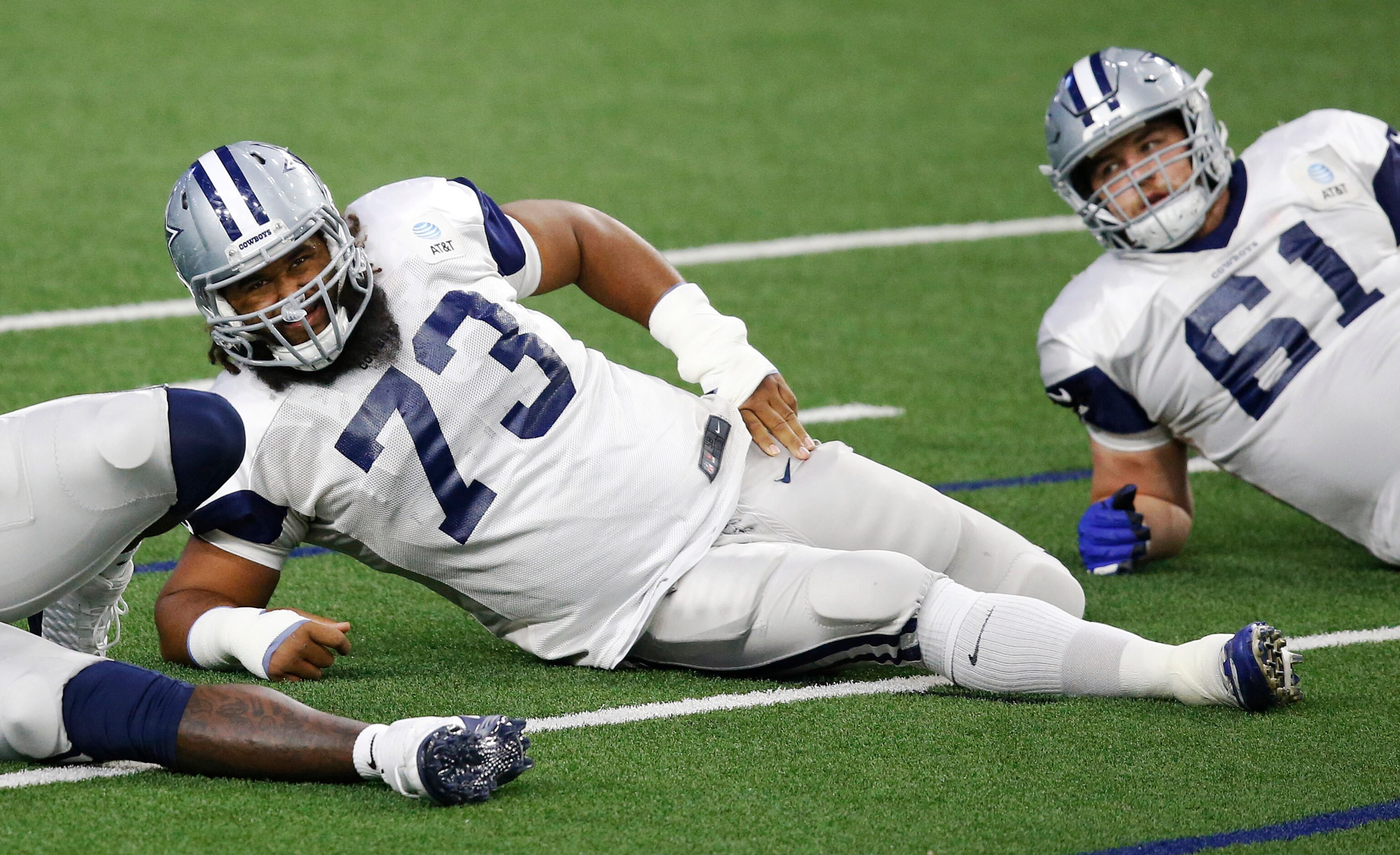 Dallas Cowboys center Joe Looney (73) stretches with teammates in practice during training...