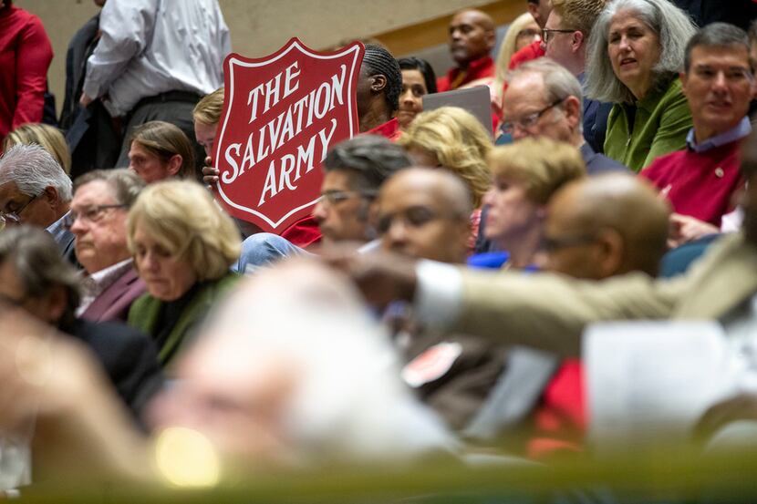 A member of the audience holds the Salvation Army's logo during a City Plan Commission...