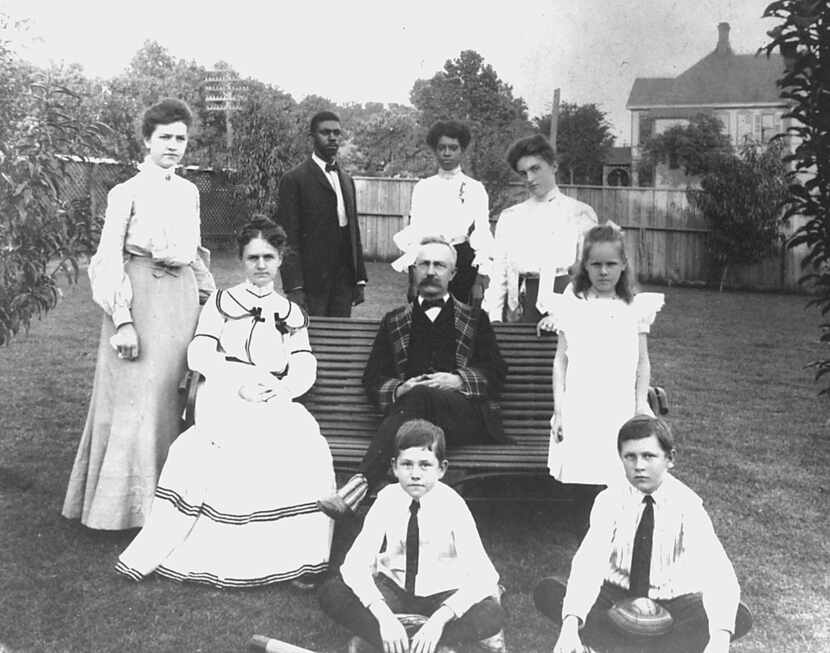 G.B. Dealey and his wife Olivia (seated, left), with their children and two household...