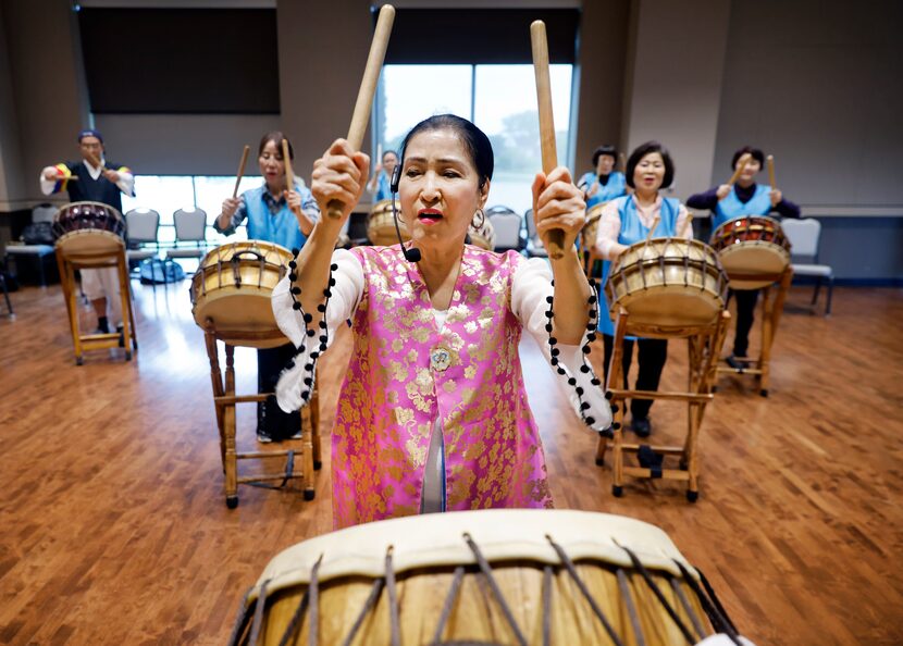 Instructor Kyong Sun Kim leads other Korean members in playing the buk as the Arirang Texas...