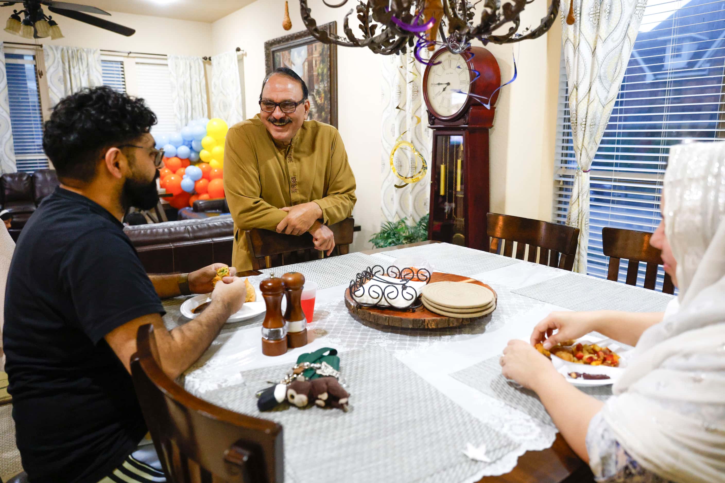 Mohammed Humayoun Butt (center) goes around the Iftar table during a family gathering on,...
