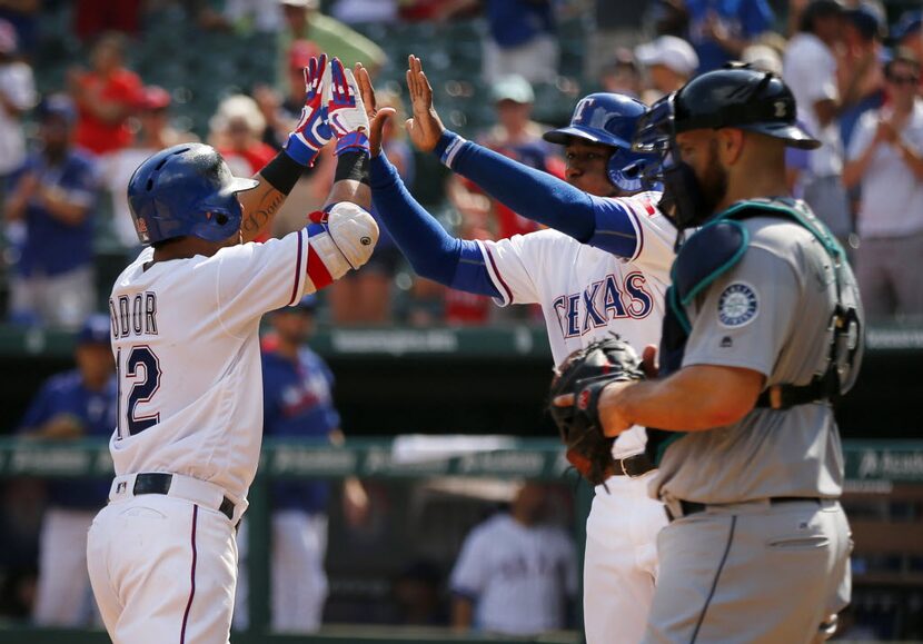 Texas Rangers second baseman Rougned Odor (12) is congratulated by Jurickson Profar (center)...