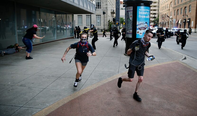 Dallas police made arrests as they cleared out downtown after a 7 p.m. curfew took effect...