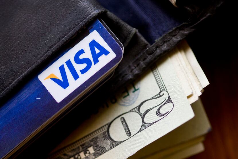 In this Feb. 2, 2011, file photo, a wallet containing cash and a Visa card is displayed in...