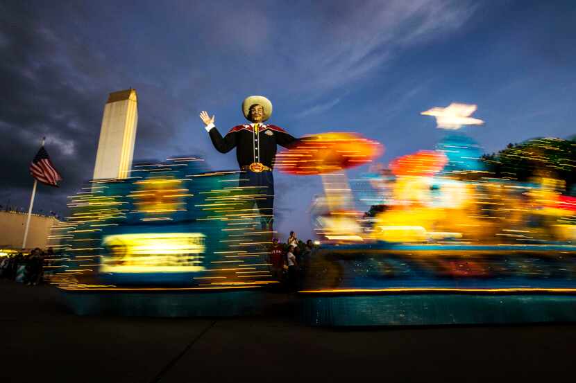 Floats roll past Big Tex during the Starlight Parade at the State Fair of Texas in Dallas on...
