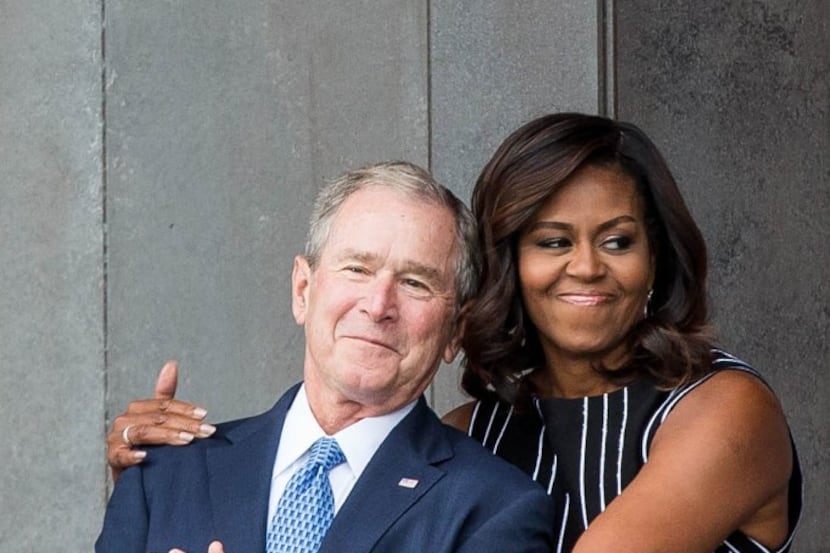 Former President George W. Bush receives a hug from first lady Michelle Obama as they attend...