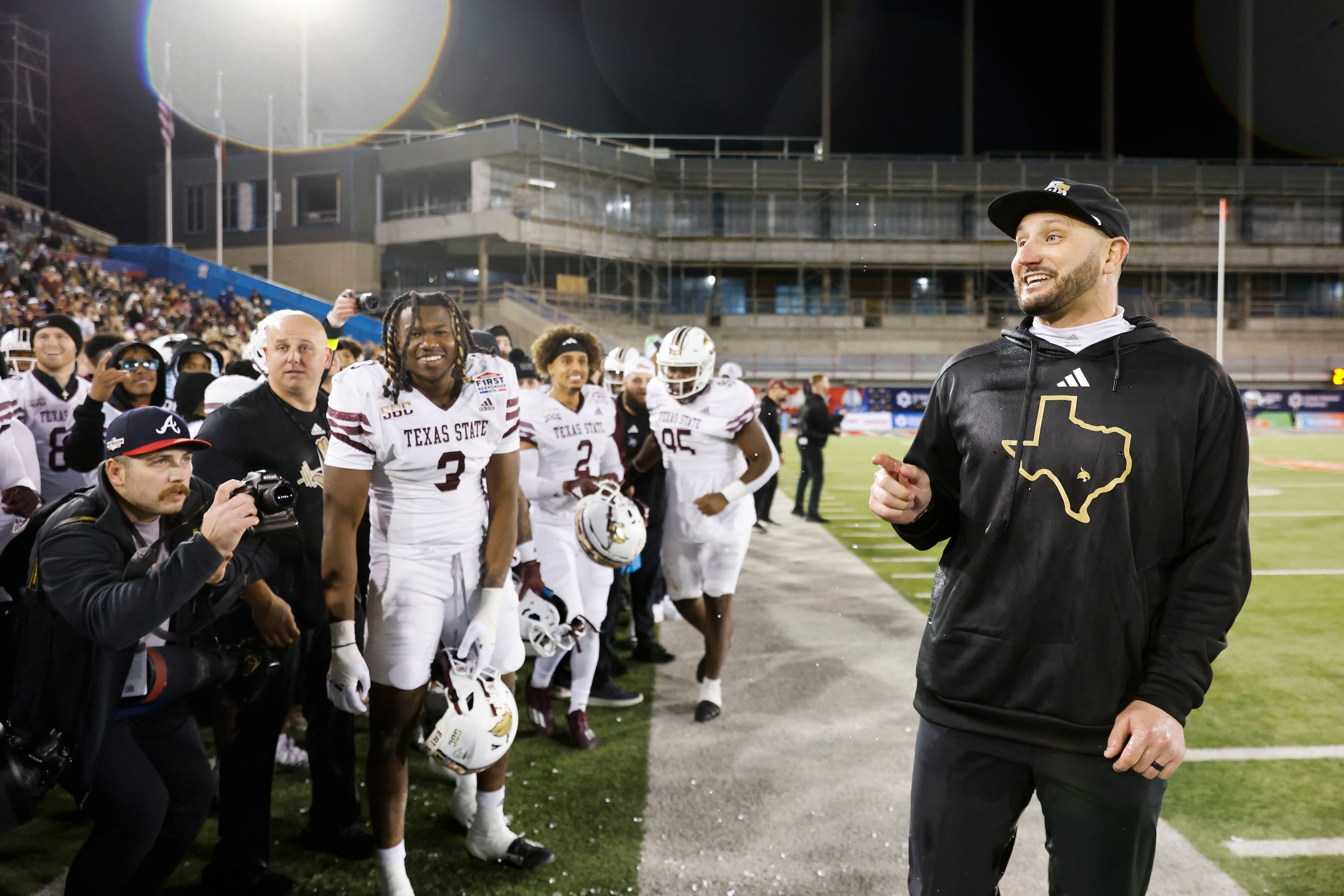 Texas State head coach GJ Kinne reacts towards the players as he is doused by water ahead of...