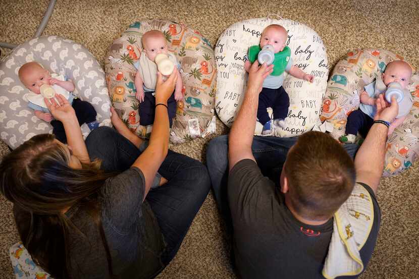 Katie and Chris Sturm feed quadruplets (from left) Hudson, Daniel, Austin and Jacob, who...