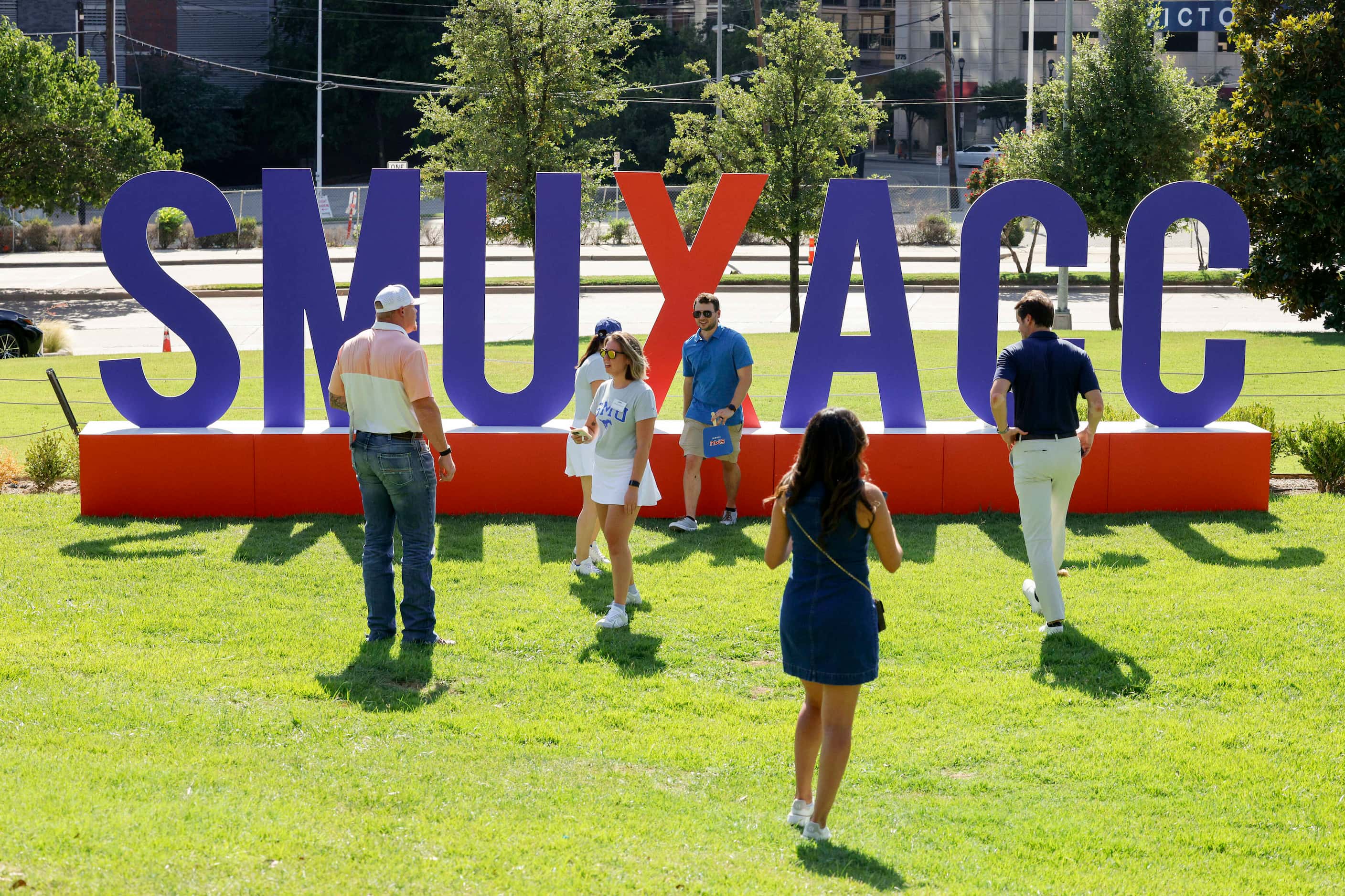 People take photos in front of a SMU and ACC sign during a celebration of SMU’s first day in...