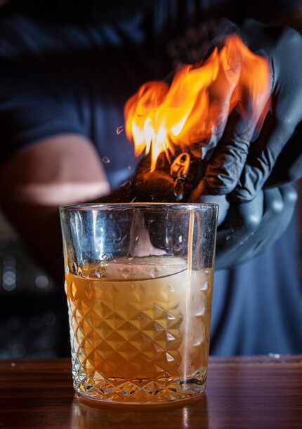 Beyond cocktails and ax throwing, there's also fire. The Lemon Honeysuckle Old Fashioned is...