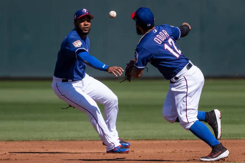 Texas Rangers second baseman Rougned Odor (12) and shortstop Elvis Andrus chase a single by...