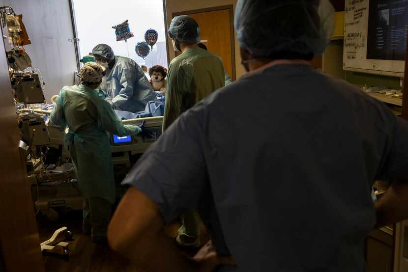 Dr. Trushil Shah (center) and a team of medical staffers prepared a intubated patient for a...