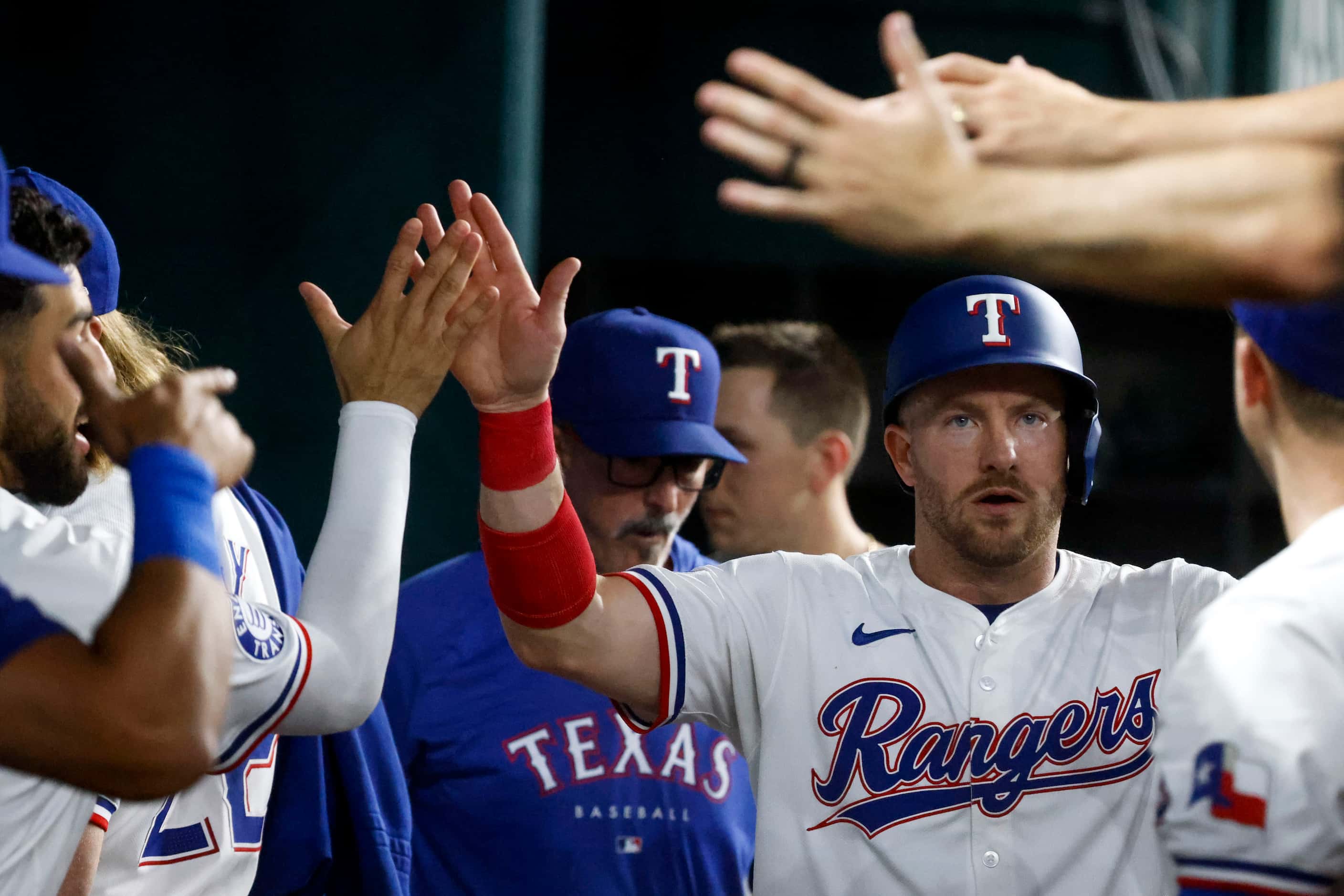 Texas Rangers' Robbie Grossman is congratulated by his teammates after scoring on a single...