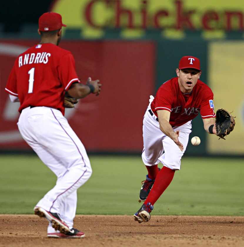 Texas Rangers second baseman Ian Kinsler (right) lobs the ball to shortstop Elvis Andrus as...