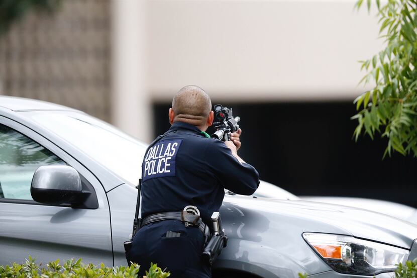 A Dallas police officer trained his rifle on a parking garage near police headquarters on...