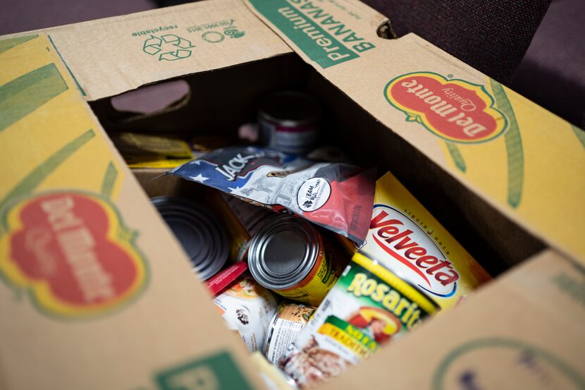 Community members are seen here working on food distribution packages for local community...