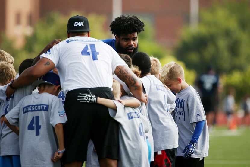 Dallas Cowboys running back Ezekiel Elliott helps to pull a huddle together while...