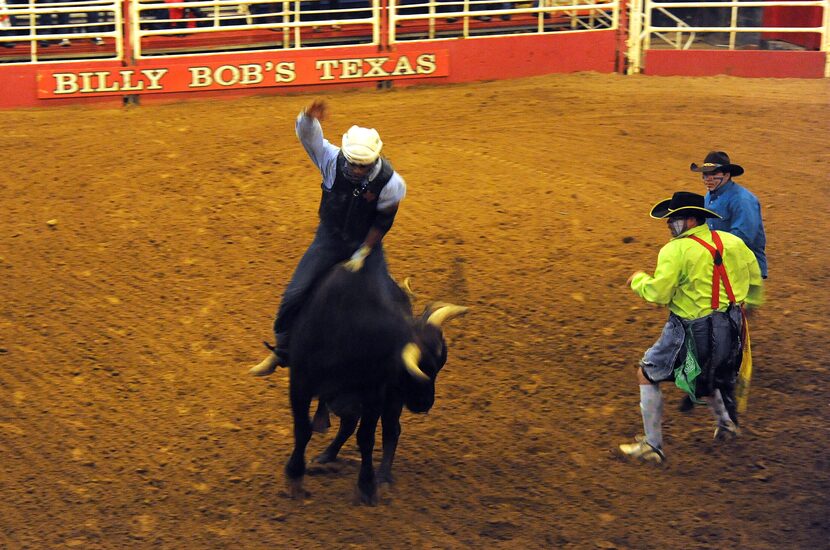 A bull rider hangs on for dear life at Billy Bob's Texas in Fort Worth, TX on January 12,...