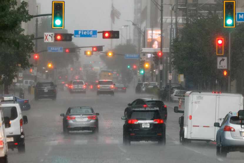 Cars drive along Commerce Street during a thunderstorm in downtown Dallas on Tuesday.