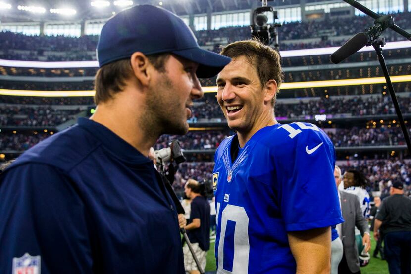 Dallas Cowboys quarterback Tony Romo (9) talks to New York Giants quarterback Eli Manning...