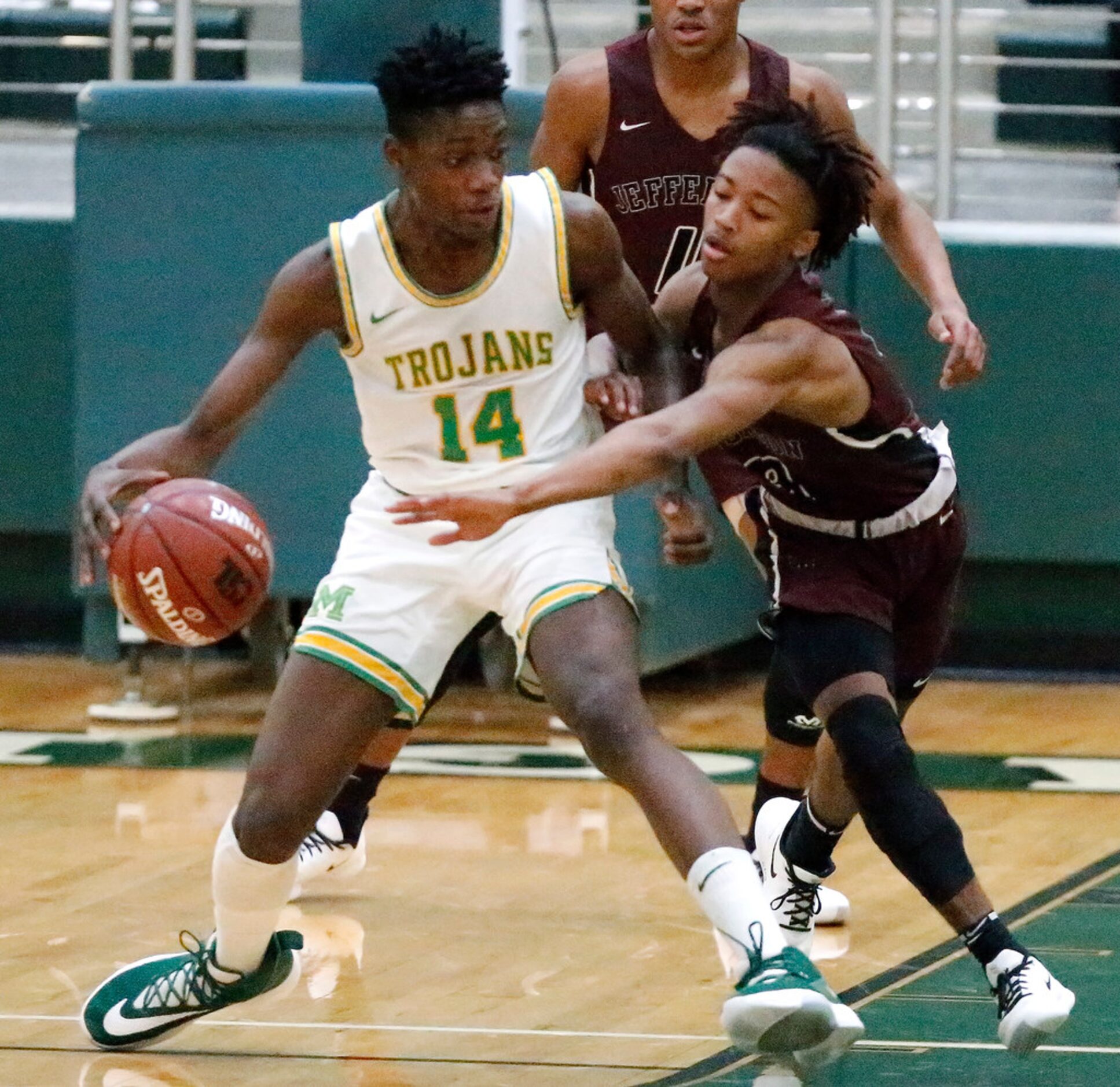 Madison High School forward Leonard Miles (14) keeps the ball Jefferson High School guard...