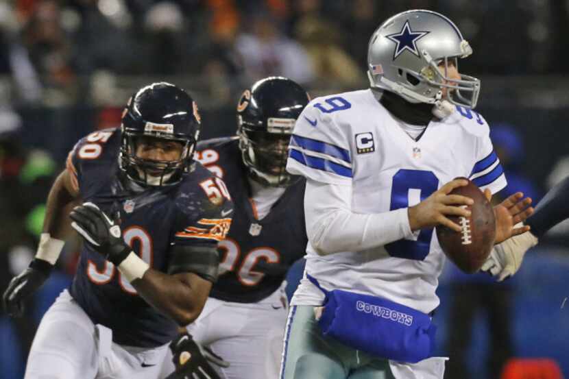 Dallas Cowboys quarterback Tony Romo (9) scrambles away from Chicago Bears outside...