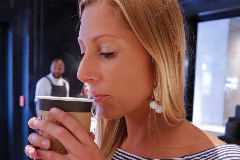 Haley Lower, with AT&T, cools a cup of the drip coffee offered at Otto's Coffee & Fine Food,...