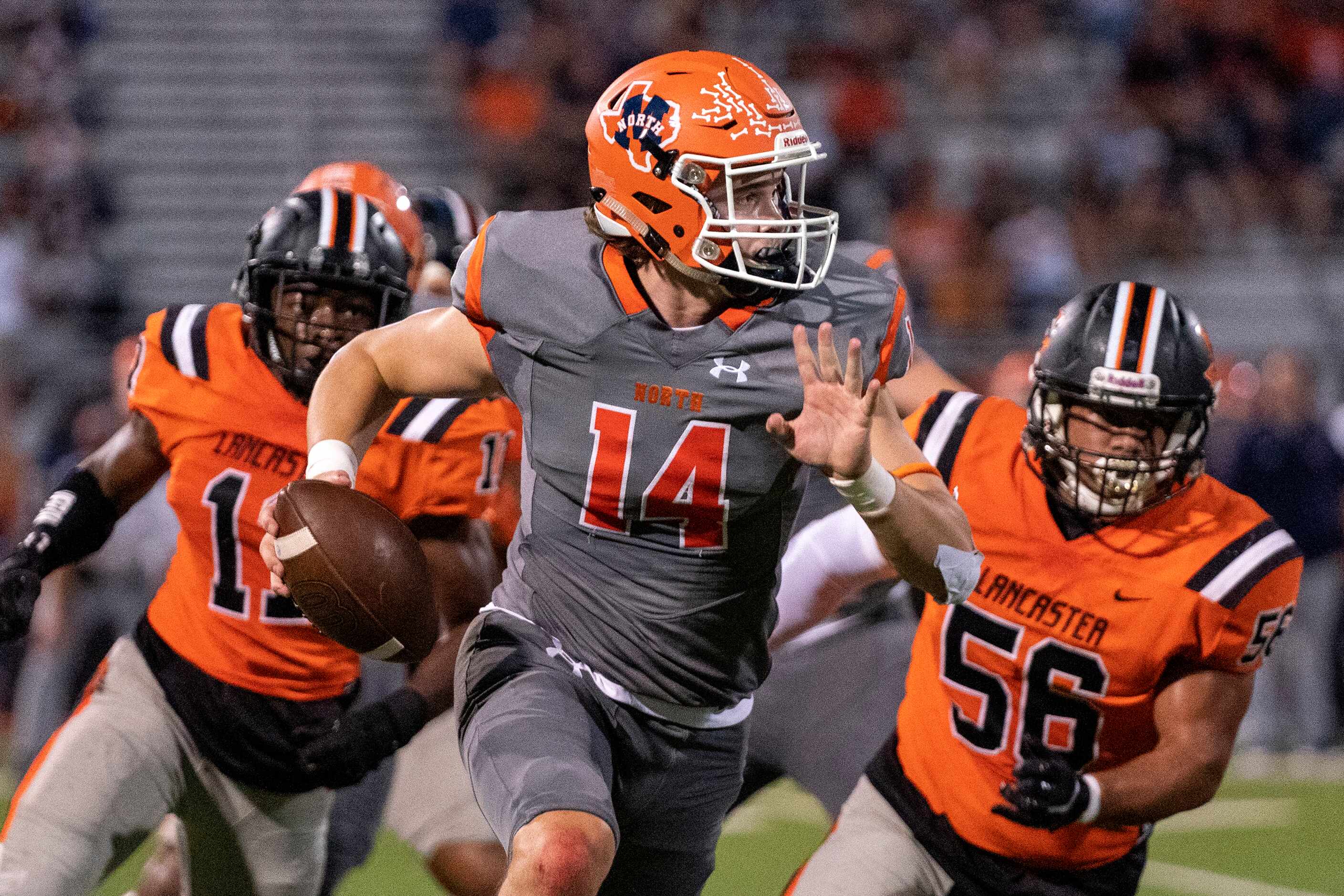 McKinney North junior quarterback Colin Hitchcock (14) rolls out to pass as he is pursued by...