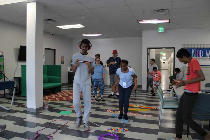 Participants play games standing up in a room at Ability Connection.