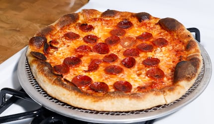 A finished pepperoni pizza sits on top of Peter Cho’s apartment oven in Dallas. It's the...
