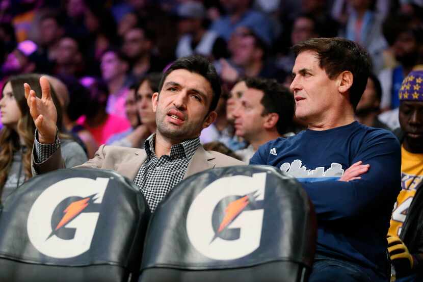 Dallas Mavericks' Zaza Pachulia, left, talks with team owner Mark Cuban, right, as he sits...