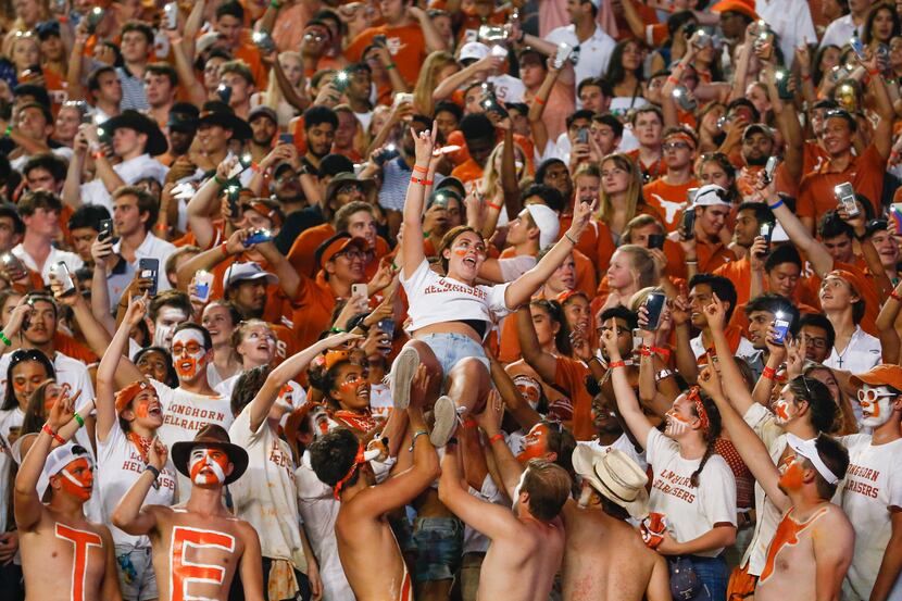 A student fan is lifted into the air during the third quarter of a college football game...