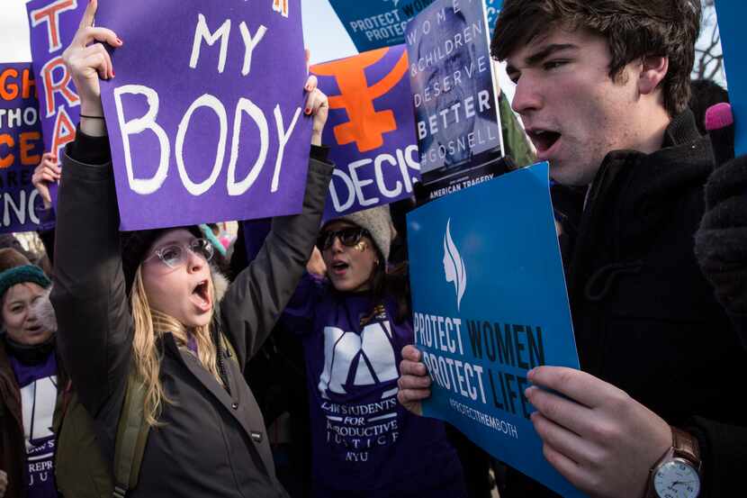 Pro-choice advocates (left) and anti-abortion advocates (right) rally outside of the Supreme...